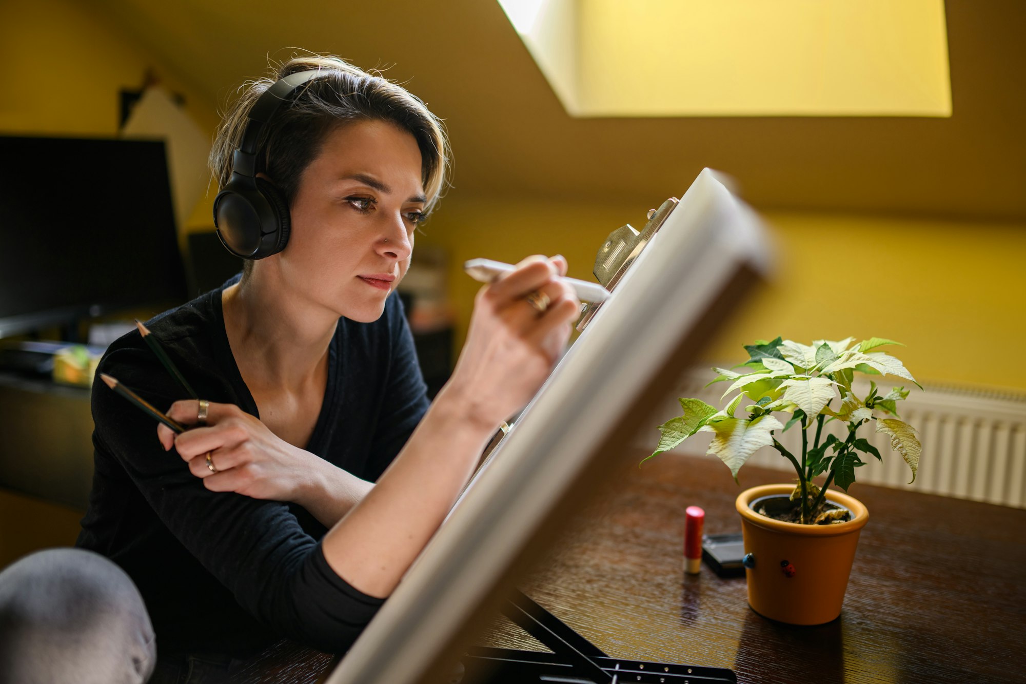 Portrait of a talented illustrator with headphones drawing sketch.